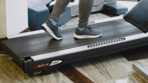 Henkilö kävelee kävelymatolla sisätiloissa – tehokas tapa lisätä arkiliikuntaa.