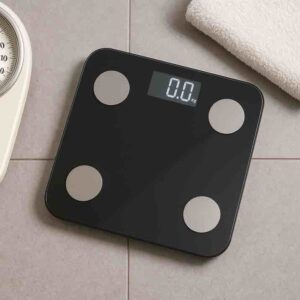 Moderni digitaalinen henkilövaaka vaalealla kylpyhuoneen lattialla.